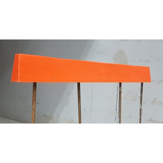 Safeline-FP's orange Rebar Protector, sitting next to a concrete wall for display of construction safety accessory use.