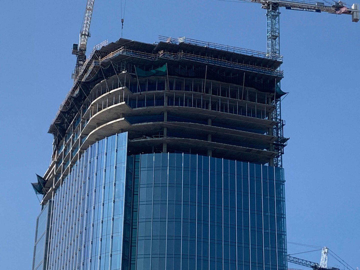 A high-rise commercial building under construction, featuring Personnel Safety Netting Systems from Safeline-FP for construction safety.